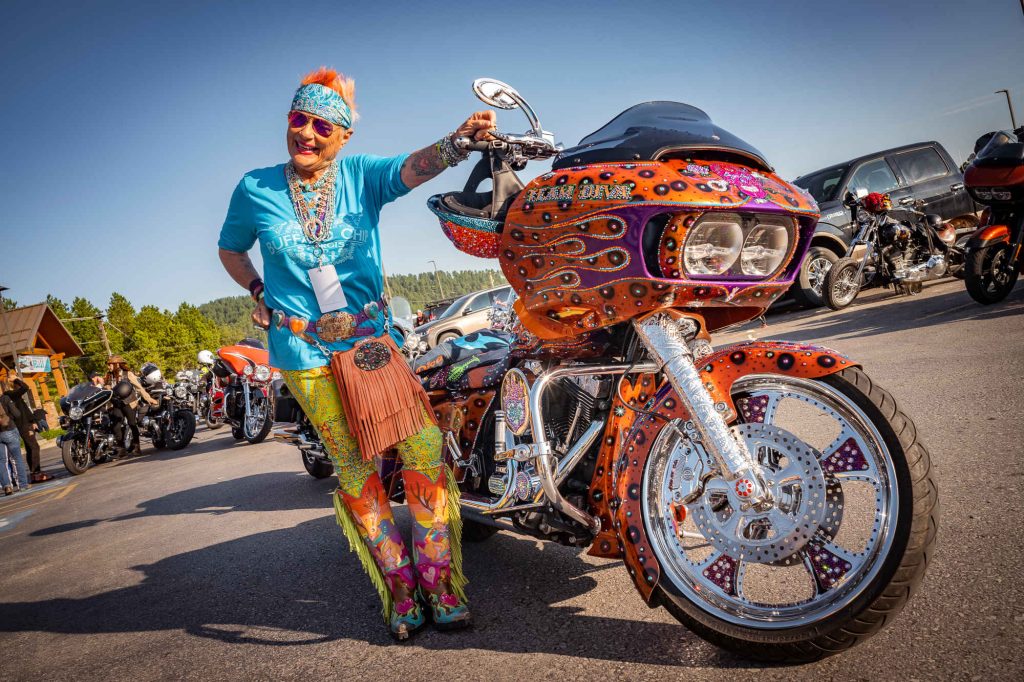 Person wearing multi-coloured outfit matching multi-coloured motorcycle