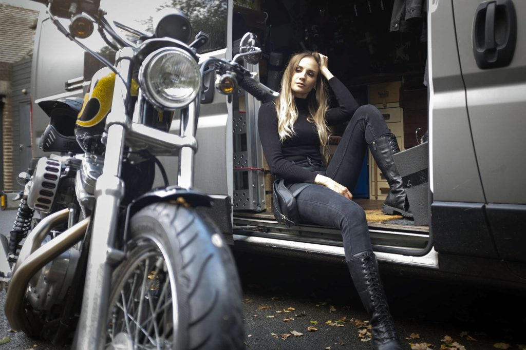 Laura sitting with her Harley-Davidson